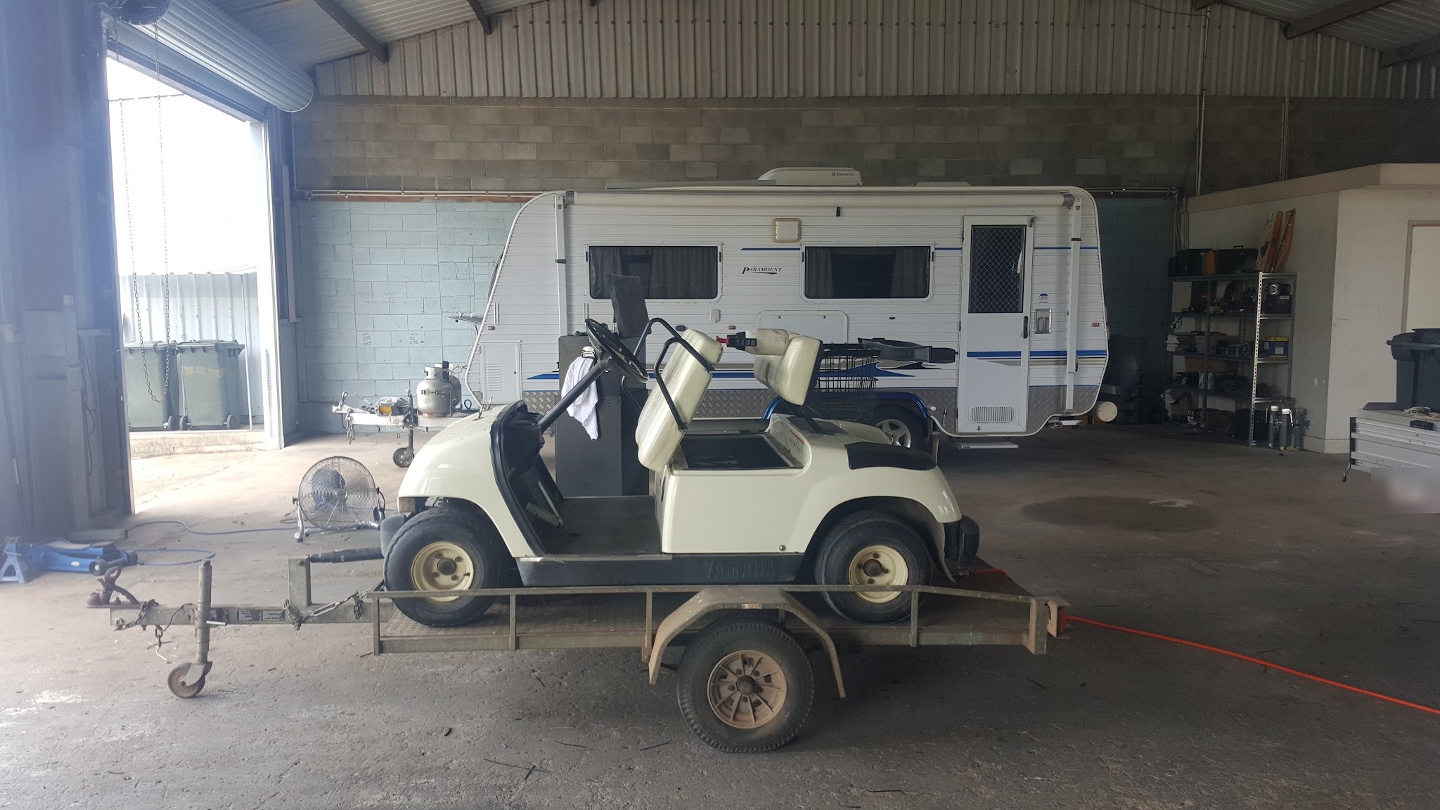 A caravan and a buggy on a trailer inside the Bundaberg East workshop